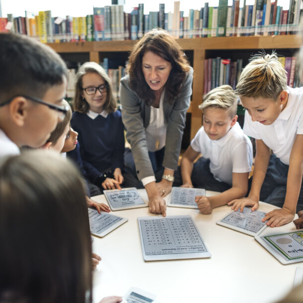 Pupils gathered around a table listening to the teacher